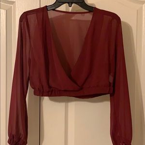 A sheer burgundy cropped blouse